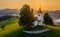 Skofja Loka, Slovenia - Aerial view of the beautiful hilltop church of Sveti Tomaz Saint Thomas with amazing golden sunrise