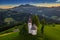 Skofja Loka, Slovenia - Aerial view of the beautiful hilltop Sveti Tomaz Saint Thomas Church with an amazing golden sunset