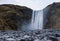 Skogafoss Waterfall In Iceland. Long Exposure Photo Shoot with Blue Sky