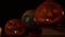 Skull with glowing eyes and two Jack pumpkins with candles inside, loop video