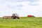 Skutech, Czech Republic, 4 June 2020: A small tractor with a rotary rake rakes freshly cut grass in the field