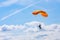 Skutech, Czech Republic, 6 August 2020: A parachutist with an orange parachute canopy blue sky and white clouds