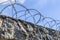 Sky and barbed wire on a stone fence