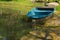 A sky-blue fiberglass boat on a lush landscaped pond in a Thai garden park.