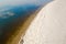 Sky and clouds bathe in the sea on the border of a sandy beach. The boundary of the meeting of the elements.