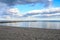 sky clouds beach sand groyne rocks blue sky water sea coast