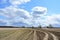 Sky, clouds. Boundless field. Winding road. Forest in the distance. Rural view of nature