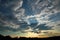 Sky, clouds, mountains, fields and dawn silhouettes.