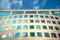 Sky and clouds reflecting on green tinted windows on generic commercial building