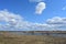 Sky, clouds. A village on the banks of the Kostroma river. Forest in the distance. Fields of young grass. Agricultural