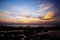 Sky with deep hanging storm clouds and wet sludge during low tide swathed in yellow and red bright light during sunset