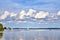 Sky with gigantic clouds over a lake with sailing boats and motor boats