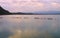 Sky mirroring on water and metal mesh fence in sea laggon