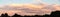 Sky panorama during sunset over forest with pastel colors sky and colorful clouds