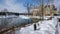 The sky reflects off the mirror-like surface of a small pond at the center of a wintry scene.