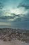 sky, sea, and rock on the beach. there is light shine through the cloud