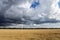 The sky with storm clouds over the wheatfield. Summer rural landscape