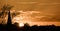 sky at sunset and silhouette of trees and church