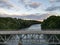 Sky View over a River cutting through a remote and rural forest with a bridge