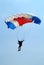 Skydiver with blue white red parachute on parachuting competition