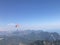 Skydiver with a dark blue canopy on the background a blue sky above clouds