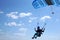 Skydiver flies with the little blue parachute, quickly approaching, close-up