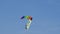 Skydiver flies on rainbow parachute with hieroglyphs on flag and gently lands.