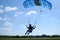 Skydiver flies under the canopy of a parachute, quickly approaching, close-up