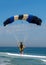 Skydiver flying over the beach.