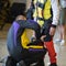 Skydiver Instructor Helps Apprentice to Tie Security Belt on His Parachutist Suit