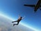 Skydiver jumps from a black plane on a hot day with clear skies.