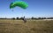 Skydiver landing his parachute on the ground.