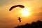 Skydiver landing the parachute at the sunset.