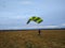 Skydiver with multi-colored parachute land on a background of cloudy sky