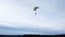 Skydiver with a multicolored parachute in the air against a white sky