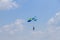 Skydiver with yellow and blue parachute against blue sky having fun in the air.