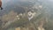 Skydivers fly in cloudy sky, try make formation. Extreme sport. Green fields.