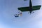 Skydivers have jumped out of a green biplane.