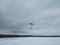 Skydivers before landing with multi-colored parachutes on the background of a winter landscape