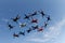 Skydiving. A group of falling people is in the blue sky.