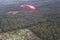 Skydiving. A parachute is above the ground.