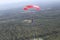 Skydiving. A parachute is above the ground.