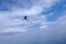 Skydiving. A sihouette of skydiver is in the cloudy sky.