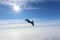 Skydiving. Skydiver is flying above white clouds.