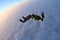 Skydiving. Sunset jump. Two skydivers are above pink clouds.