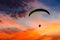 Skydiving sunset landscape of parachutist flying in soft focus. Para-motor flying silhouette with sun set. Silhouette of paraglide