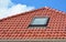 Skylight on red ceramic roof tiles house roof. Modern Roof Skylight. Attic Skylights Home Design. Roofing Construction.