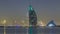 Skyline of Dubai by night with Burj Al Arab from the Palm Jumeirah .