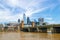 Skyline of London viewed over Thames River and London Bridge under beautiful blue sky with whispy clouds