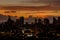 Skyline of Manila and Manila Bay during a fiery orange sunset. Near silhouette image of city.